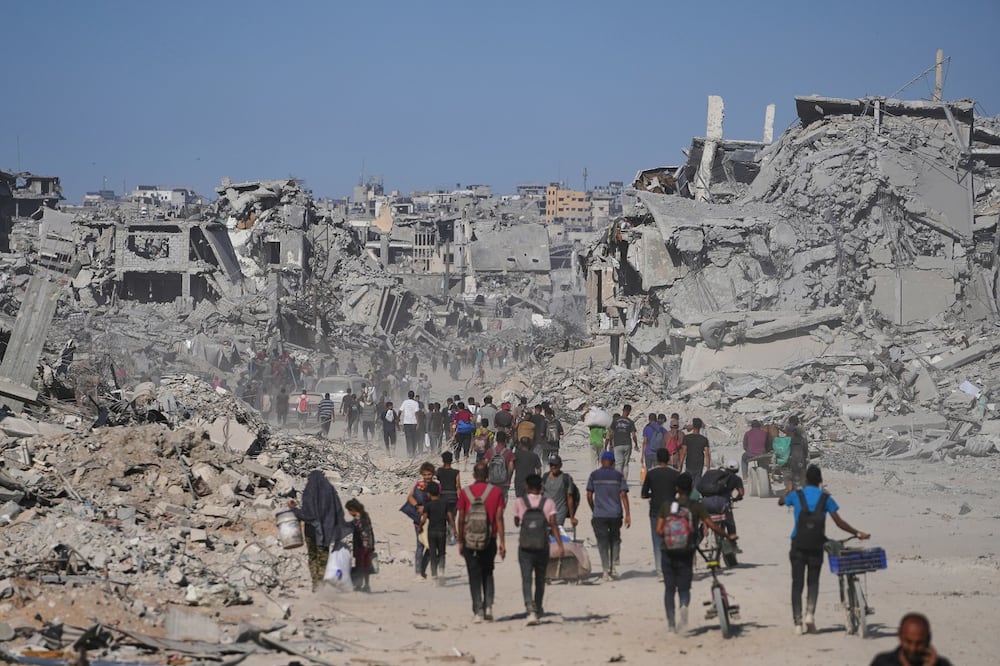 Palestinos desplazados caminan junto a edificios destruidos mientras regresan a sus hogares en el barrio de Zeitoun, en la ciudad de Gaza. Foto: AP
