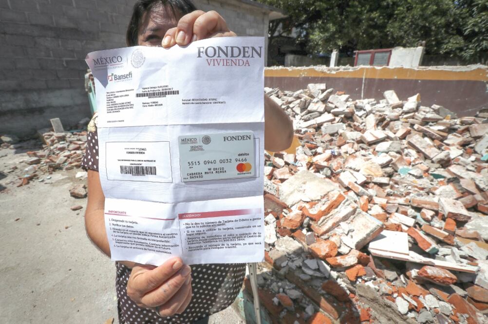 Mirsa Cabrera enseña la tarjeta que le dieron de apoyo para reconstrucción, dice que sólo le dieron para daño parcial. (JUAN CARLOS REYES. EL UNIVERSAL)