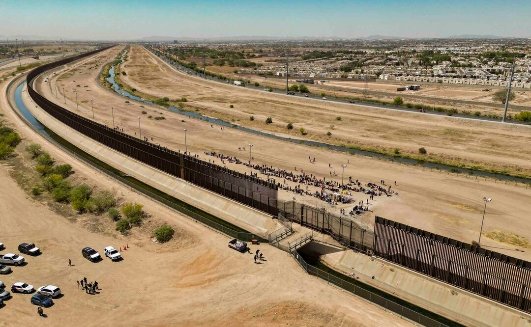 Fotografía aérea tomada hoy muestra a cientos de migrantes mientras esperan por papeles junto al muro fronterizo en El Paso, Texas. Foto: EFE