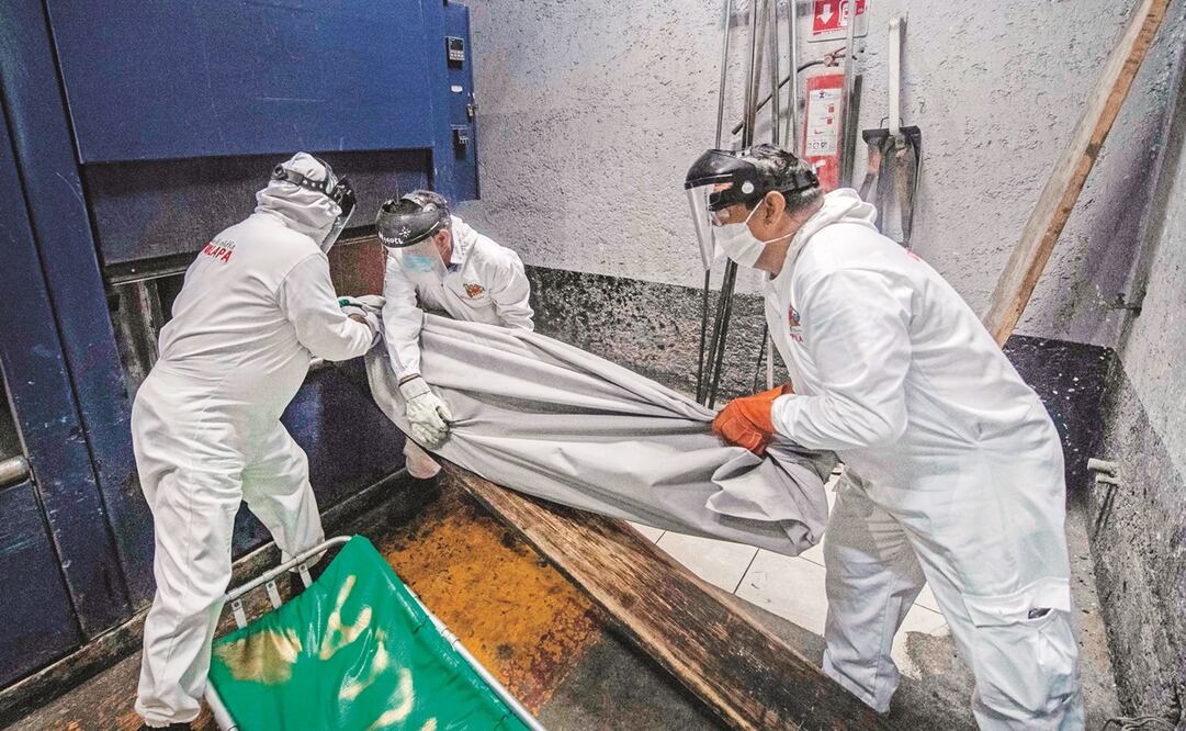 Empleados del panteón de Iztapalapa, antes de cremar los restos de una víctima de Covid-19 en un horno en la Ciudad de México, en 2020.Pedro Pardo/AFP