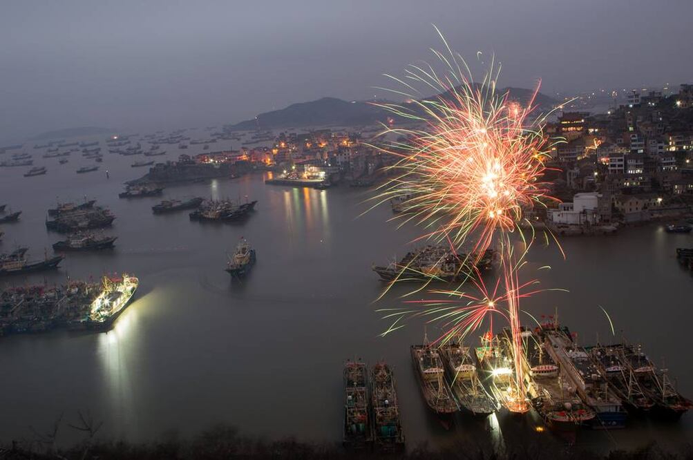 Fuegos artificiales iluminan el cielo sobre el puerto pesquero de Shitang para celebrar el Año Nuevo Lunar chino, en Wenling, provincia de Zhejiang, en el este de China (XINHUA)