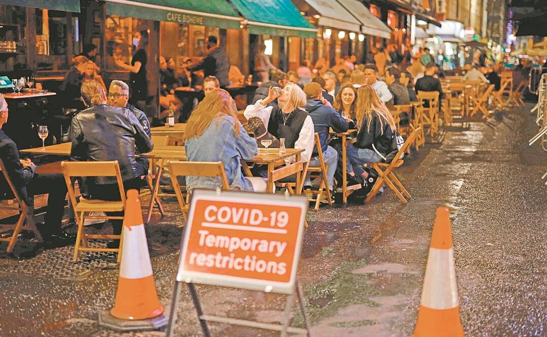 Un bar en Londres lucía lleno ayer. En estos locales se aplican nuevas restricciones que incluyen el cierre a las 22:00 horas a partir de hoy. Foto: TOLGA AKMEN. AFP