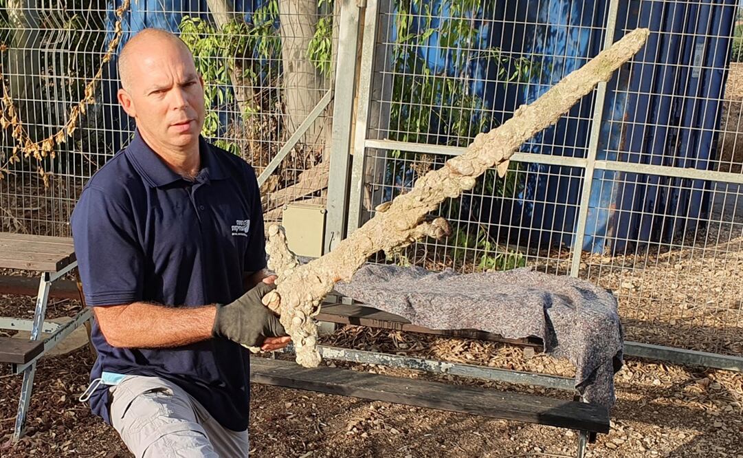 Nir Distelfeld, inspector de la Unidad de Prevención de Robos de la Autoridad de Antigüedades de Israel, posa con la espada hallada en el mar Mediterráneo. Foto: EFE/ Autoridad de Antigüedades de Israel/Anastasia Shapiro