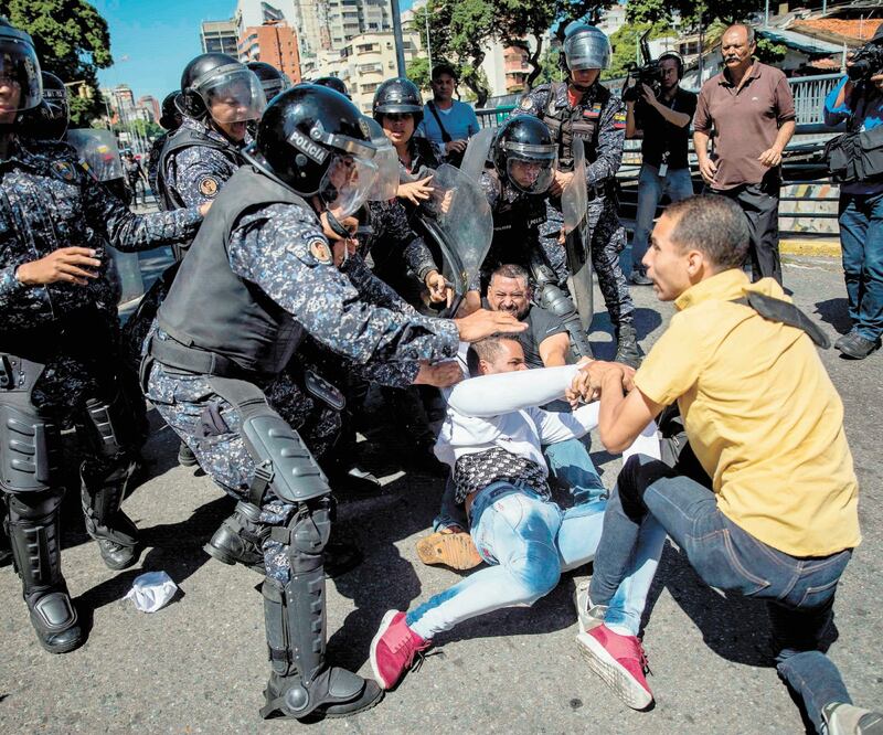 La policía bolivariana evita el paso de un grupo de personas que asistieron a una manifestación convocada por el líder opositor, Juan Guaidó. Foto/MIGUEL GUTIÉRREZ. EFE