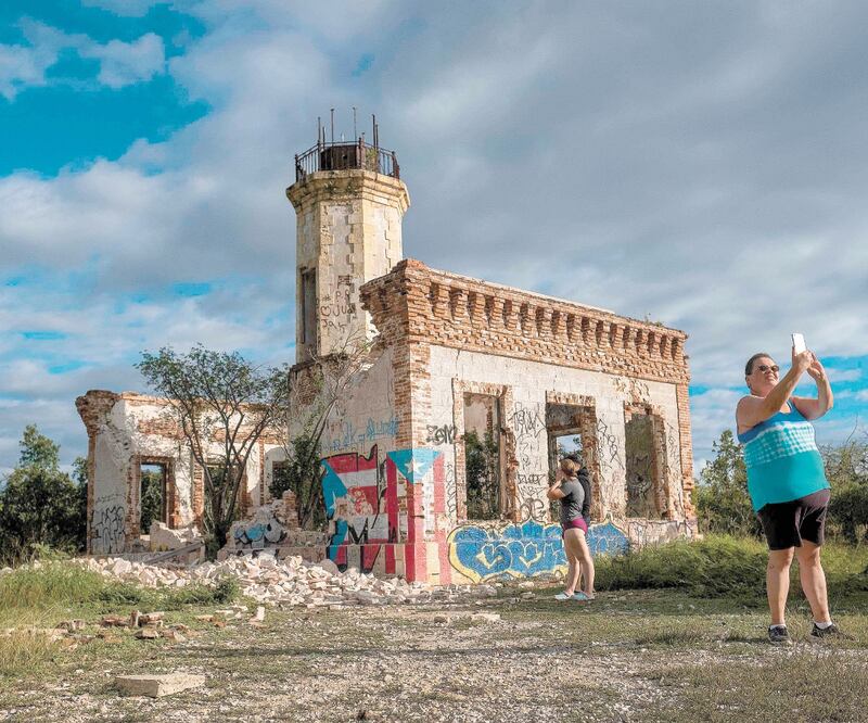 Turistas se toman foto frente a las ruinas del Faro de Guánica, en San Juan, dañado por el sismo de ayer. RICARDO ARDUENGO. AFP