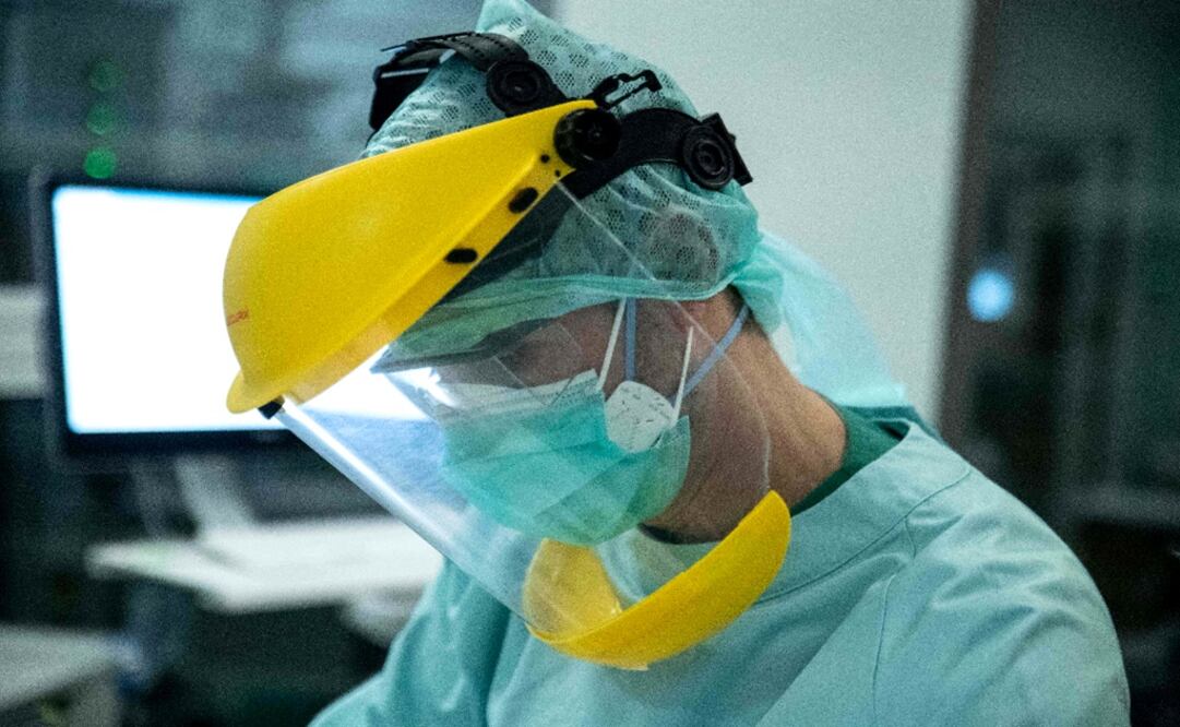 A nurse wearing protective gear tends to patient – Photo: Aris Oikonomou / AFP	