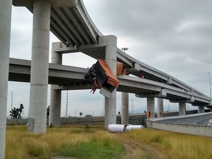 Tráiler sufre volcadura y queda suspendido de una columna