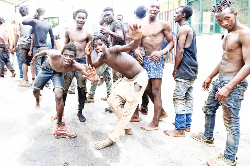 Migrantes africanos celebran tras lograr atravesar, ayer, la valla fronteriza en la ciudad española de Ceuta y llegar a un albergue temporal. (FABIAN BIMMER. REUTERS)