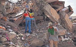 Habitantes intentan recuperar sus pertenencias en el lugar donde se derrumbó un edificio en Caraballeda, estado de La Guaira. Foto: Martin Bernetti/ AFP