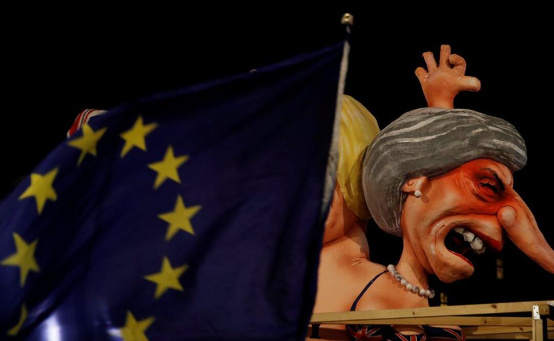 Una bandera de la Unión Europea frente a una caricatura de la primer ministra de Reino Unido, Theresa May (Foto: Reuters)