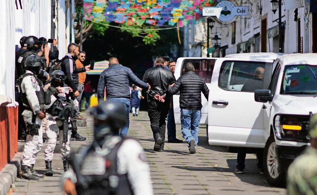 Elementos de la Fiscalía estatal de Michoacán trasladan a uno de los policías que resguardaban a Carlos Manzo; ayer fueron detenidos por su presunta participación en el crimen. Foto: Eduardo Verdugo / AP