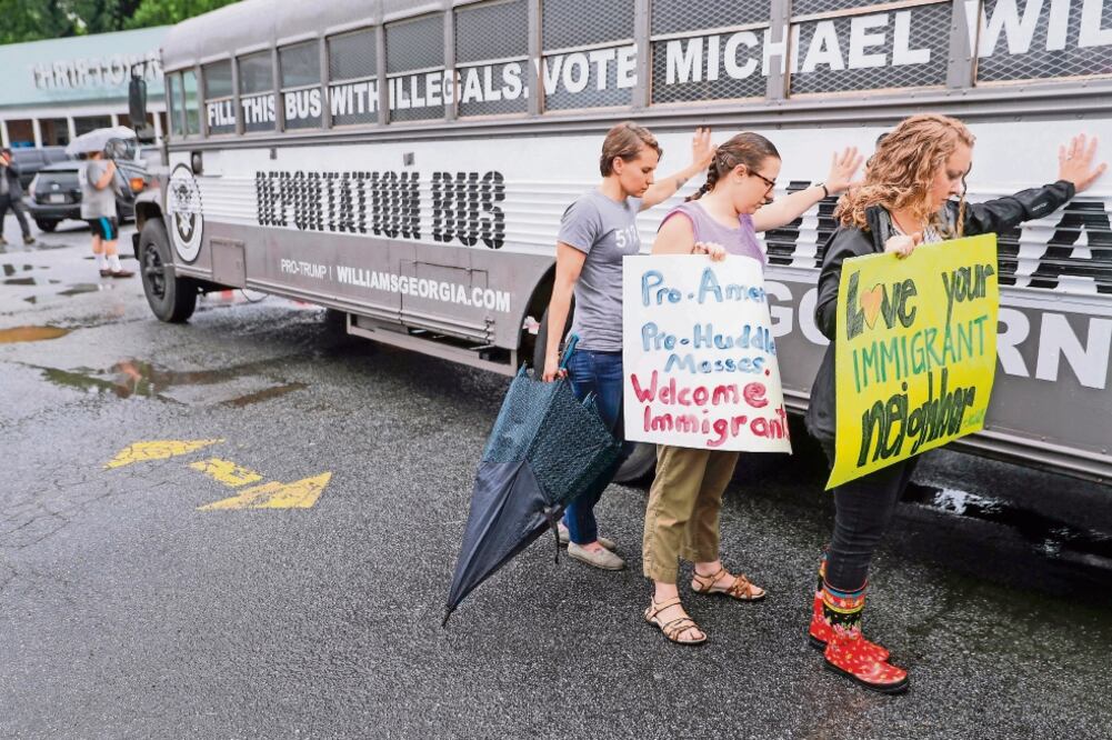 Manifestantes rodean en Clarkson el “autobús de la deportación”, del candidato republicano a la gubernatura de Georgia, Michael Williams. (ERIK S. LESSER. EFE)