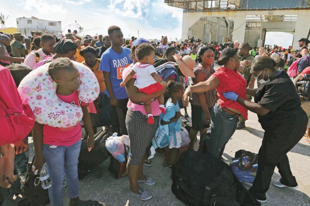 Una oficial de las Bahamas revisa a la gente que busca subir a un barco en Marsh Harbor. Foto: FERNANDO LLANO. AP