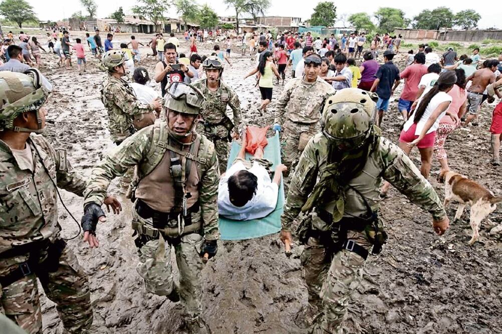 Soldados ayudan a desalojar a una persona luego de las afectaciones por las lluvias, en Catacos, en el departamento peruano de Piura (OSCAR FARJE. XINHUA)