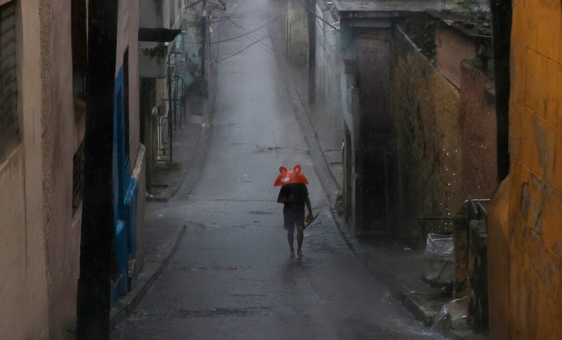Una persona se protege de la lluvia este martes, en Santiago de Cuba (Cuba). El Instituto de Meteorología (Insmet) de Cuba prevé que Melissa impacte en su extremo oriental como un huracán "extremadamente peligroso", probablemente como un categoría 4 (de 5) en la escala Saffir-Simpson. (28/10/25) Foto: EFE/Archivo