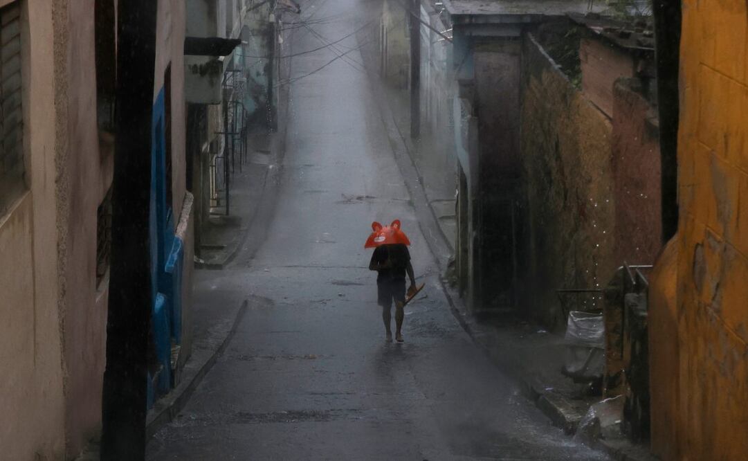 Una persona se protege de la lluvia este martes, en Santiago de Cuba (Cuba). El Instituto de Meteorología (Insmet) de Cuba prevé que Melissa impacte en su extremo oriental como un huracán "extremadamente peligroso", probablemente como un categoría 4 (de 5) en la escala Saffir-Simpson. (28/10/25) Foto: EFE/Archivo