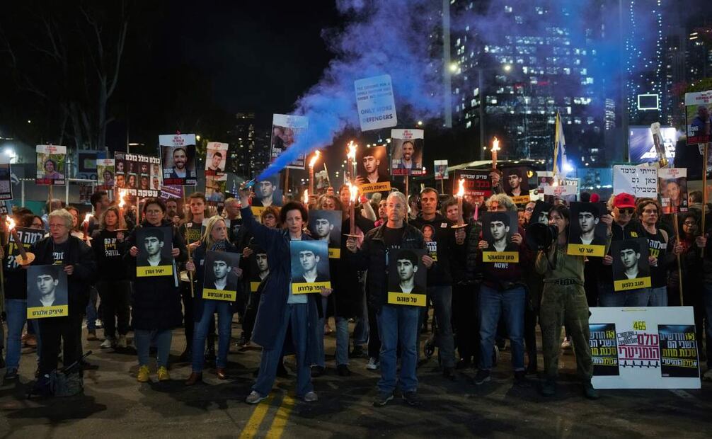 Manifestantes sostienen antorchas durante una protesta para pedir la liberación inmediata de rehenes en la Franja de Gaza retenidos por el grupo armado Hamas, en Tel Aviv, Israel, el lunes 13 de enero de 2025. Foto: AP