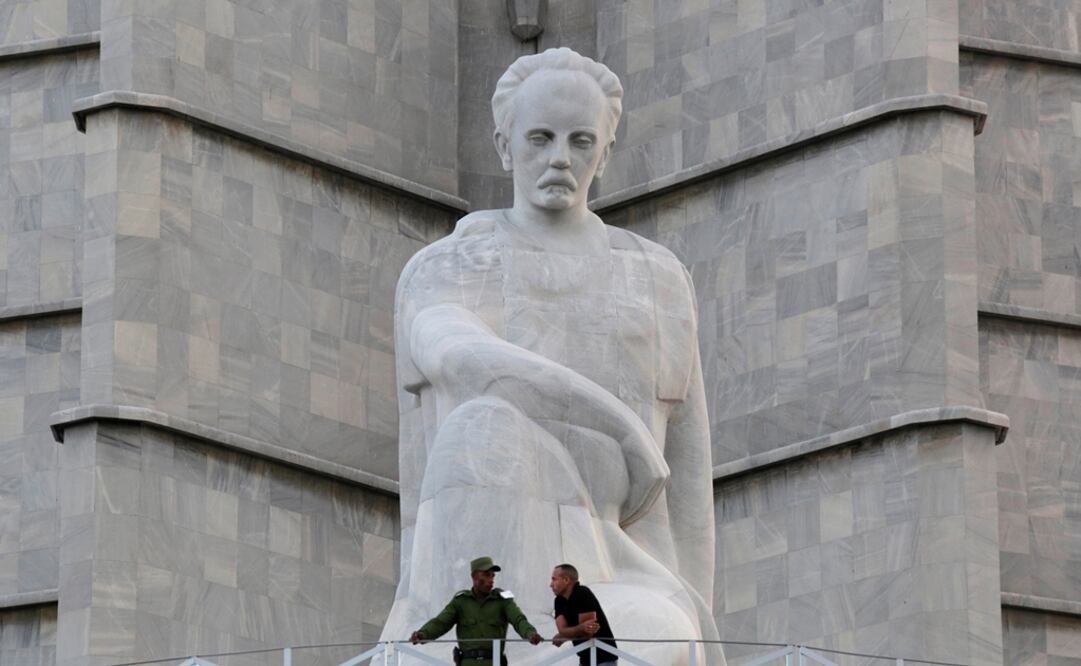 Dos oficiales están parados bajo una estatua a José Martí. Foto: REUTERS/Enrique De La Osa, archivo