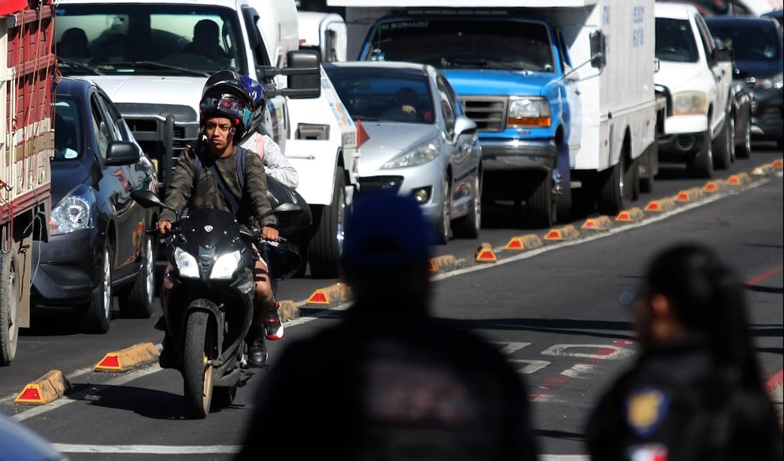 Un par de jóvenes con el caso mal puesto e invadiendo el carril exclusivo para el Metrobús circulan sobre la avenida Eduardo Molina al cruce con el Eje 1 Norte en la Ciudad de México. Foto: Carlos Mejía archivo/EL UNIVERSAL