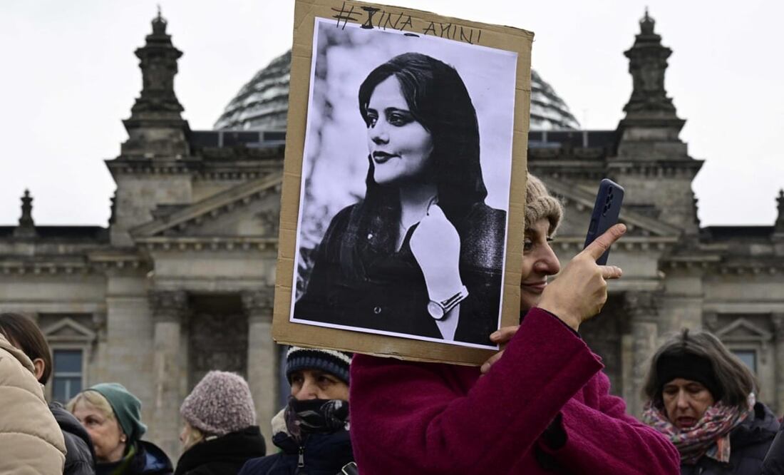 Una mujer se toma una selfie mientras sostiene un retrato de Mahsa Amini, una joven iraní que murió después de ser arrestada en Teherán por la policía de moralidad de la República Islámica. Foto: AFP