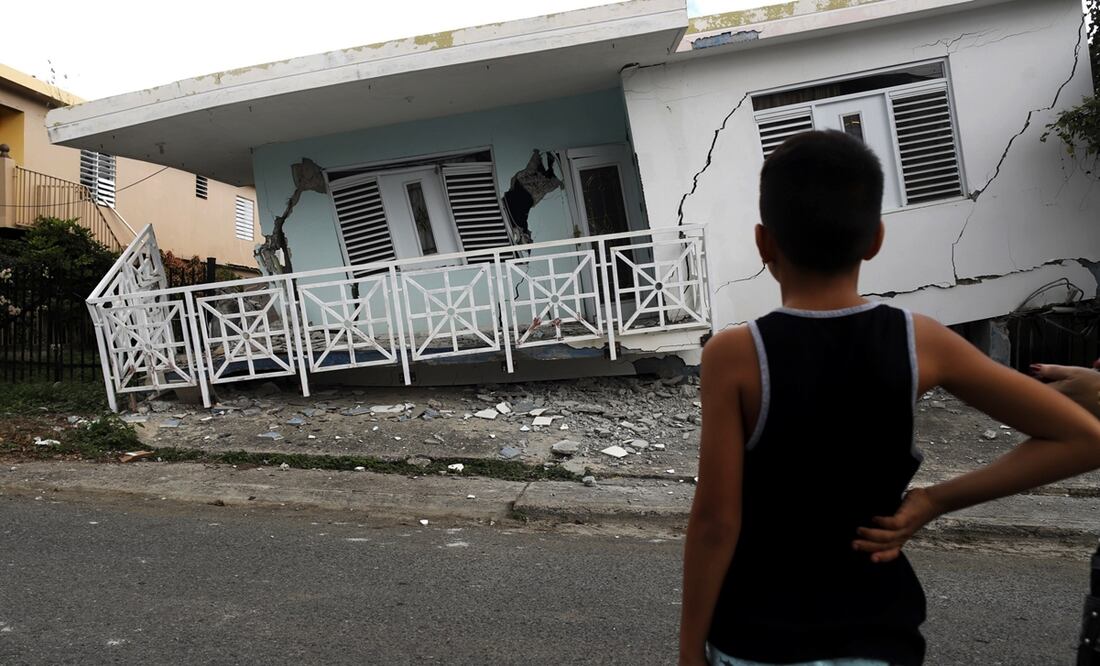 Un niño observa una casa dañada por el temblor de magnitud 5.8 que se reportó el pasado 6 de enero en Puerto Rico. Foto: EFE