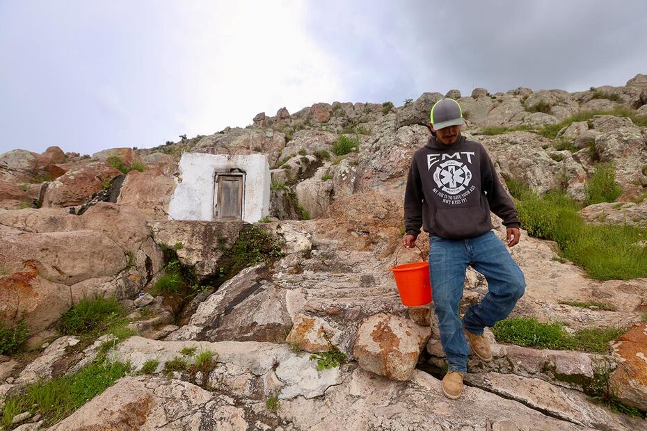Una pequeña construcción color blanco resguarda uno de los pozos que emana agua de entre las rocas en la comunidad Ejido Ojuelos en San Diego de la Unión. Arnulfo, 20 años, baja con una cubeta llena de líquido. Es agua que usan para beber y cocinar.