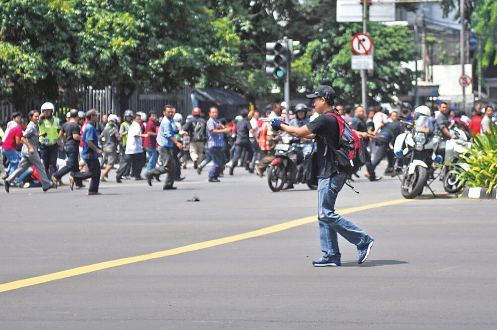 Un atacante amaga con una pistola en la calle Thamrin, que se encuentra en el corazón de Yakarta, Indonesia, donde se albergan rascacielos de oficinas y las mayores cadenas hoteleras, además de embajadas (VERI SANOVRI. XINHUA)