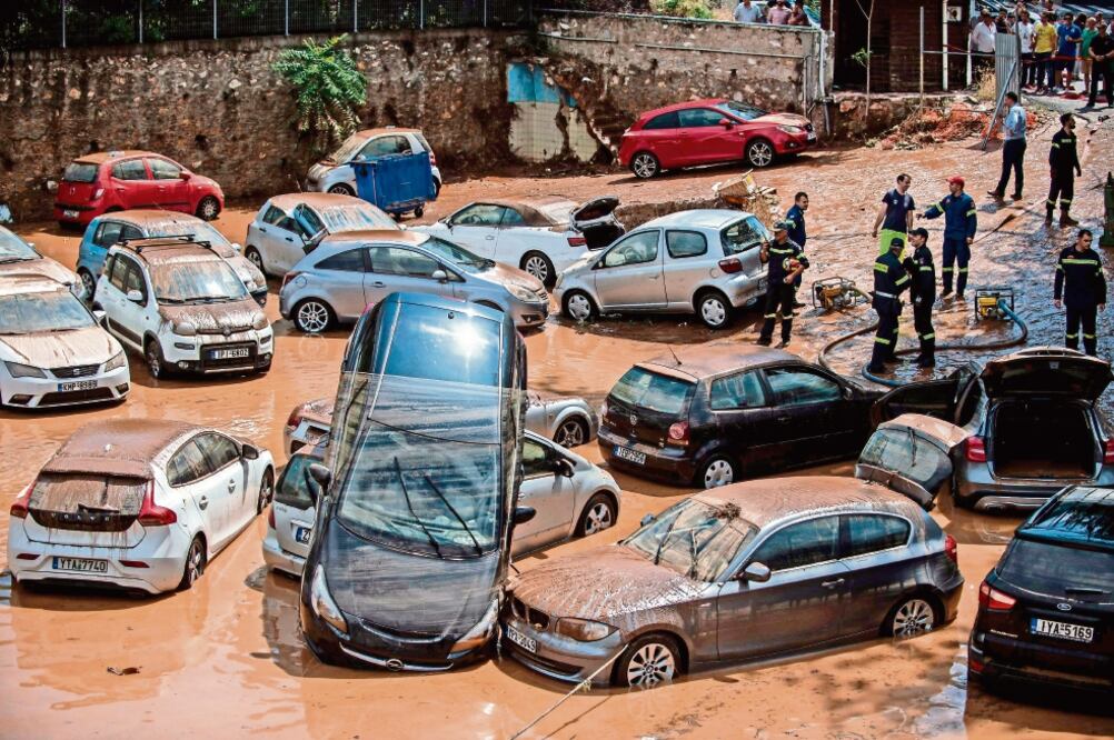Las fuertes lluvias registradas ayer en Atenas ayudaron a apagar los incendios en la zona pero también provocaron inundaciones en la capital (ANGELOS TZORTZINIS. AFP)