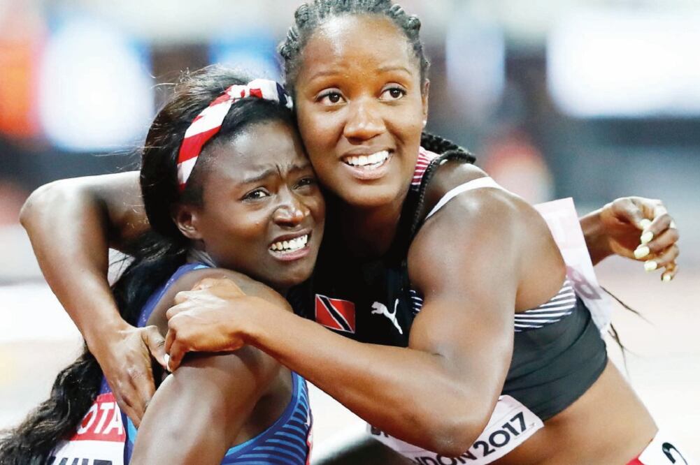 Tori Bowie, de EU y Kelly-Ann Baptiste, de TyT se abrazan al ver el resultado. (LUCY NICHOLSON. REUTERS)