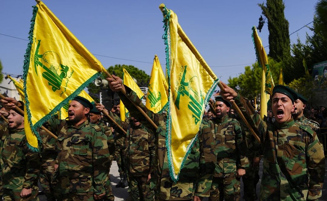 Los combatientes de Hezbolá izan la bandera de su grupo y gritan consignas. Foto: AP