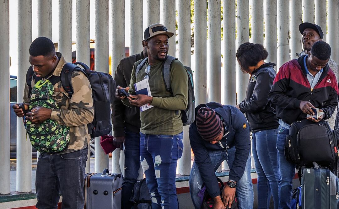 Grupos de migrantes hacen fila para cruzar a Estados Unidos y continuar con su proceso de asilo. Foto: EFE