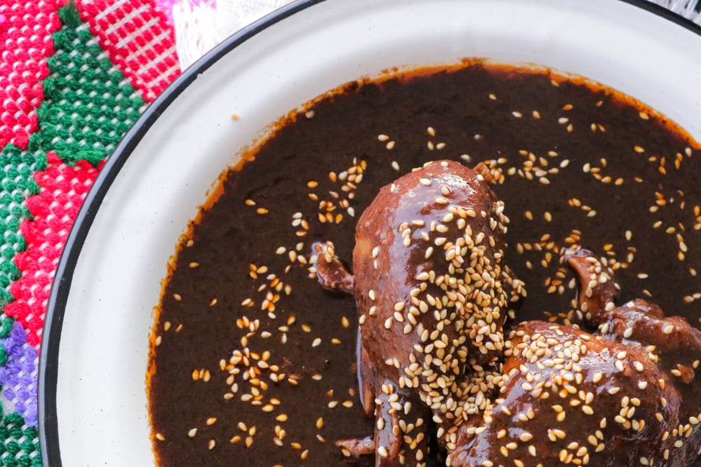El mole tradicional servido con ajonjolí es una de las especialidades principales en la Feria del Mole y el Tamal 2026. Foto: Canva.