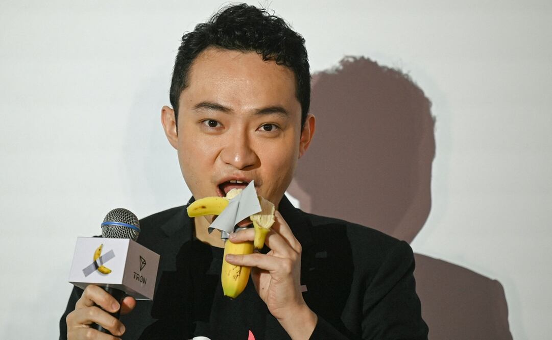 El fundador de la criptografía, nacido en China, Justin Sun, come una obra de arte compuesta por un plátano fresco pegado a una pared con cinta adhesiva, en Hong Kong el 29 de noviembre de 2024, después de comprar la provocativa obra de arte conceptual del artista italiano Maurizio Cattelan. Foto: AP.