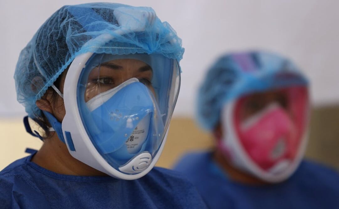Dr. Diana Pacheco, left, and nurse Claudia Flores Martinez prepare to attend to their next patient, as they conduct COVID-19 testing inside a mobile diagnostic tent – Photo: Rebecca Blackwell/AP