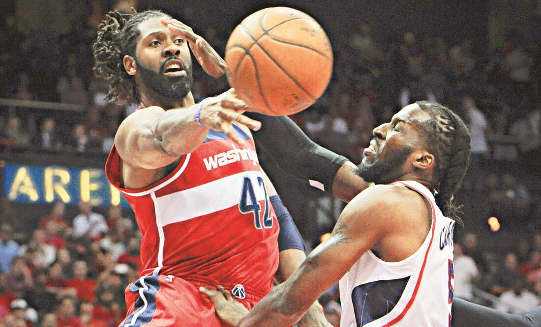 Nené Hilario (izq.) disputa un balón contra DeMarre Carroll, quien fue el principal encestador de los Hawks