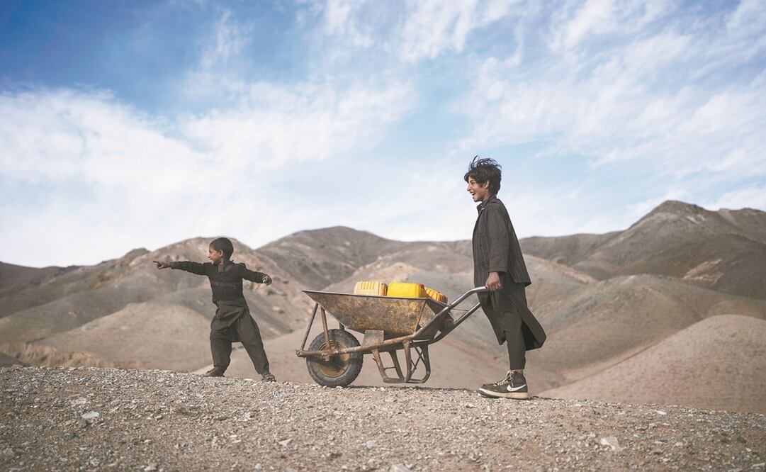 Dos hermanos llevan botellas de plástico para rellenar con agua de un estanque lejano, en Herat, Afganistán, país que vive la peor sequía en décadas. Foto: PETROS GIANNAKOURIS. AP