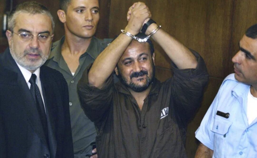 Marwan Barghouti (centro) levanta las manos esposadas el primer día de su juicio en el Tribunal de Distrito de Tel Aviv, el 14 de agosto de 2002. Funcionarios de Hamás afirman que cualquier acuerdo de alto el fuego con Israel debería incluir la liberación del prisionero Marwan Barghouti, líder del principal rival político del grupo militante. La exigencia de Hamas subraya el papel central que desempeña Barghouti en la política palestina, incluso tras más de dos décadas en prisión y condenado por Israel a múltiples cadenas perpetuas. Foto: AP