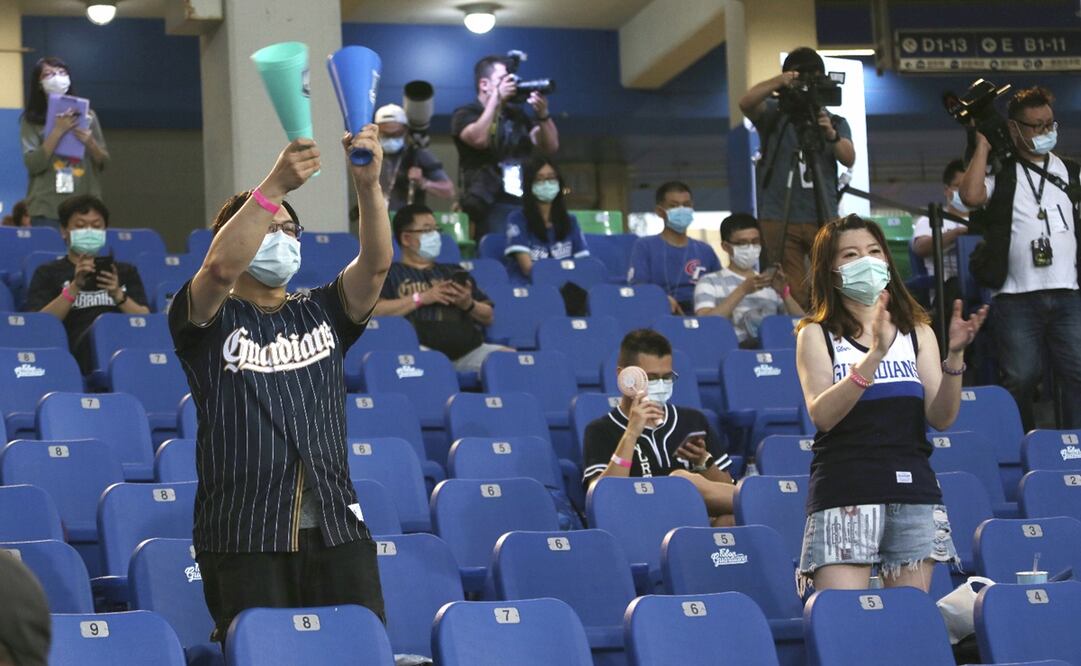 En Taiwán, espectadures ya disfrutan de un partido de baseball en un estadio, pero con distanciamiento social y cubrebocas. Foto: AP