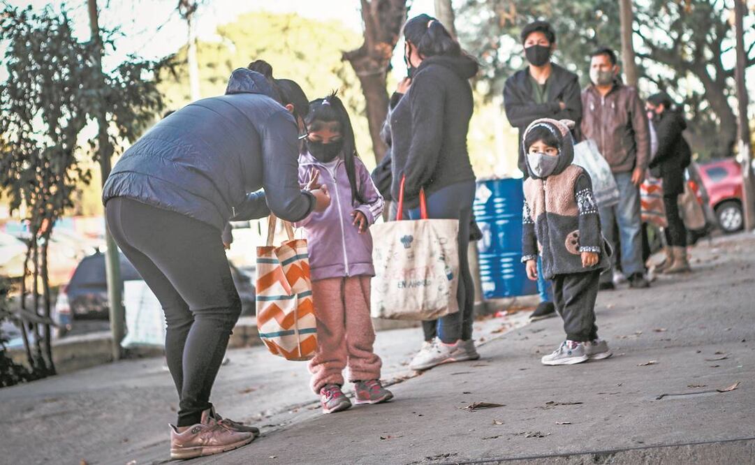 Lugareños esperan para recibir alimentos frente a un comedor, el 27 de mayo, en Buenos Aires. Foto: Juan Ignacio Roncoroni/ EFE.