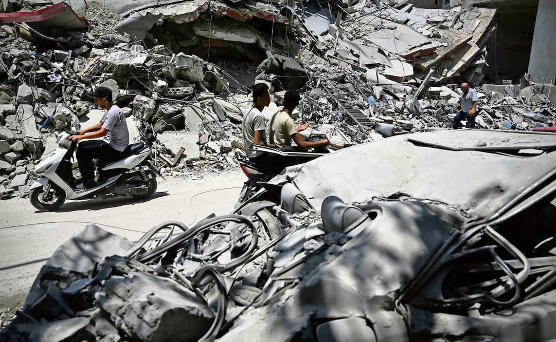 Libaneses pasan por un edificio destruido por los ataques israelíes en Tiro. Foto: Joseph EID / AFP