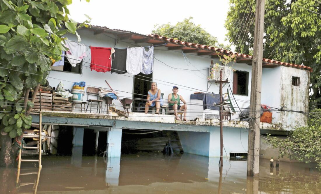 Una familia permanece sentada en la planta alta de su casa, en Asunción, que quedó parcialmente bajo el agua de los ríos desbordados por las incesantes lluvias, que han caído desde hace algunos días (JORGE ADORNO. REUTERS)