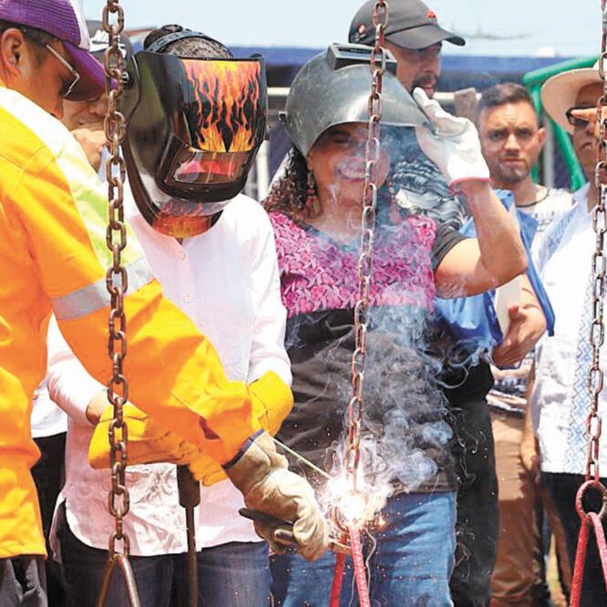 La jefa de Gobierno (izquierda, blusa blanca), asistió a la apertura de un Pilares en la alcaldía Iztapalapa, donde soldó unos columpios. Foto/ESPECIAL