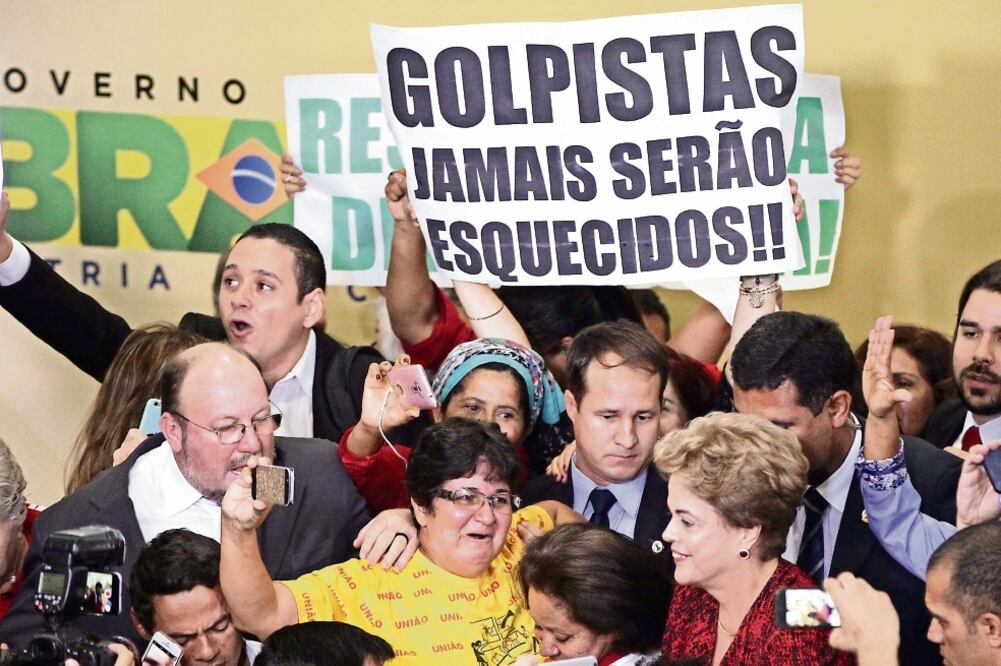 La presidenta brasileña, Dilma Rousseff (der.), al participar ayer en un encuentro con docentes y estudiantes en el Palacio del Planalto, en Brasilia. En la pancarta se lee: “Los golpistas jamás serán olvidados” (FERNANDO BIZERRA JR. EFE)