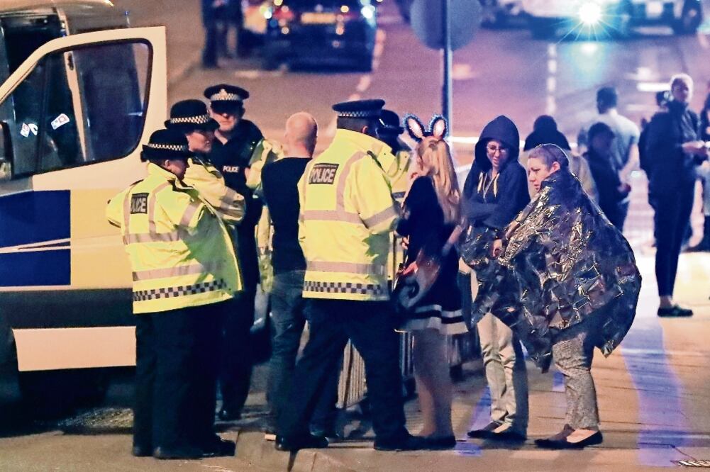 Personal de los servicios de emergencia dan información a la gente afuera de la Arena Manchester (PETER BYRNEL. AP)