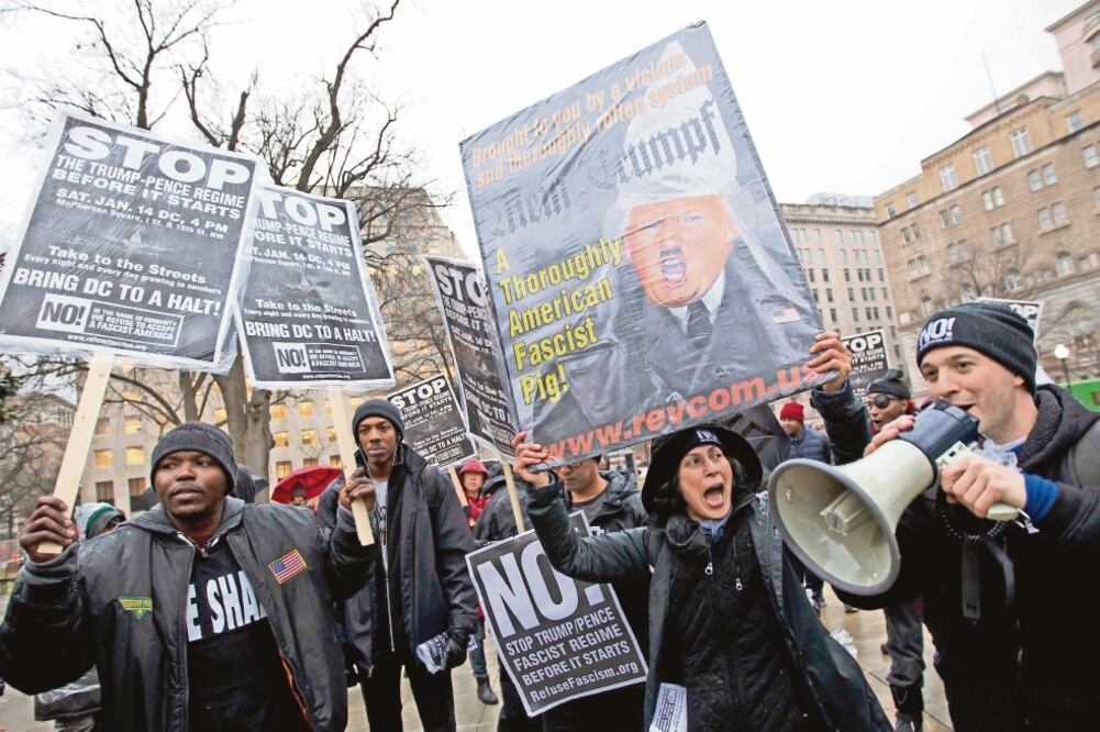 Manifestantes sostienen pancartas donde comparan a Donald Trump con Hitler, en la protesta de ayer en la Plaza McPherson, en Washington (JOSE LUIS MAGANA. AP)