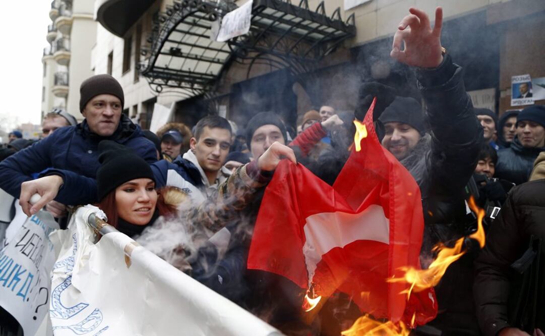 Varios manifestantes rusos queman una bandera turca mientras protestan delante de la Embajada de Turquía en Moscú (Foto: EFE)