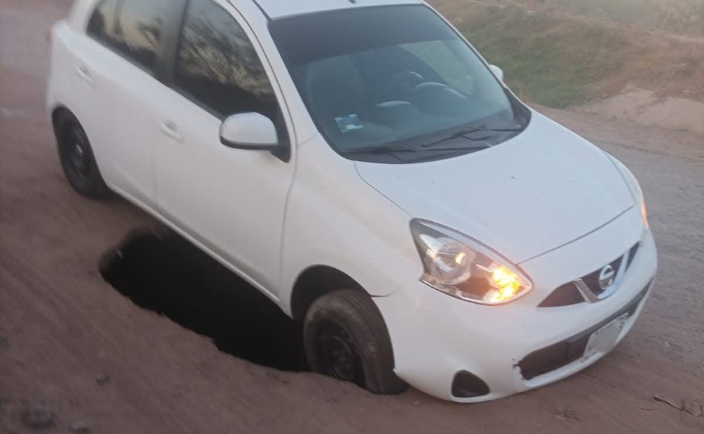 Socavón “devora” vehículo en Ciudad Obregón, Sonora; conductor logra ponerse a salvo.
Foto: Especial.