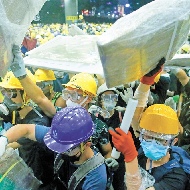Manifestantes, tras irrumpir anoche en el Parlamento de Hong Kong, donde hicieron pintas y destruyeron mobiliario. THOMAS PETER. REUTERS