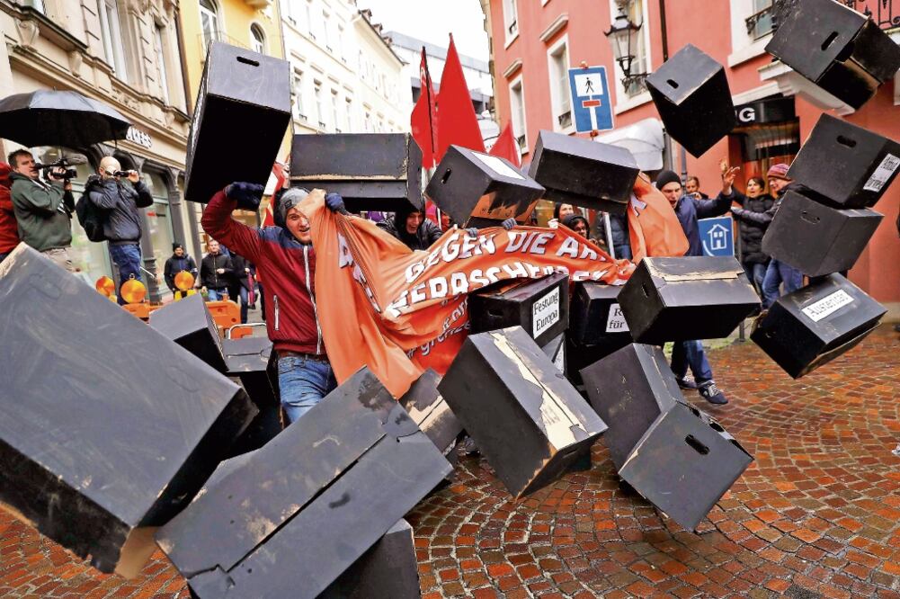 Manifestantes rompieron un muro simbólico en protesta por la reunión ministerial del G-20, en Alemania. (KAI PFAFFENBACH. REUTERS)