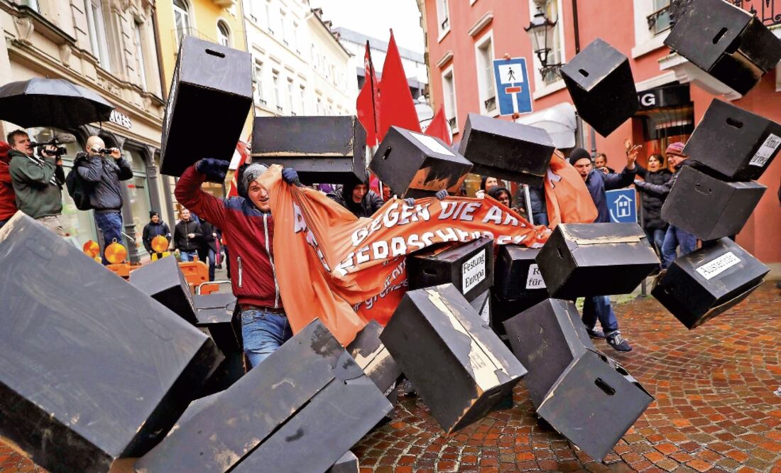 Manifestantes rompieron un muro simbólico en protesta por la reunión ministerial del G-20, en Alemania. (KAI PFAFFENBACH. REUTERS)